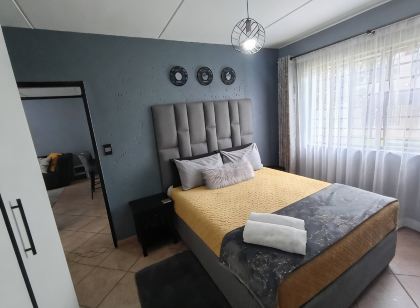 2 Bedroom apartment with 2 queen size beds & a cot, 10 minutes from JHB Airport.