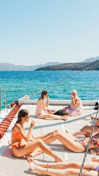 Santorini dynamic red catamaran tour in Greece with swimming at white beach/red beach and optional sunset
