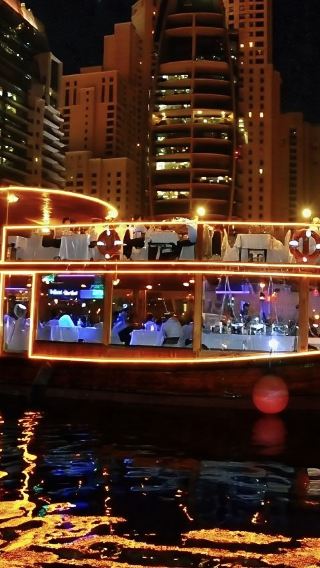Dubai Creek cruise - New city classic night tour featuring a traditional double-decker wooden boat with dining, transfers, and performances included