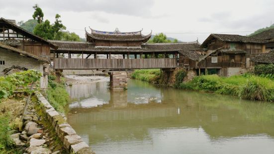 永庆桥的一头靠着村里的公路，一头隐藏在村庄里的老屋群中，外观