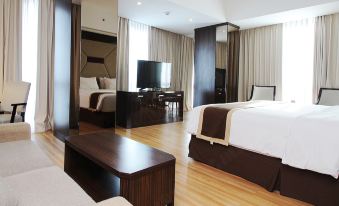 a modern hotel room with wooden flooring , white beddings , and a living area containing a flat - screen tv and dining table at Java Palace Hotel