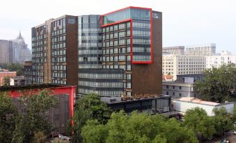 has numerous windows on its sides and front, making it a prominent office tower at Livefortuna Hotel