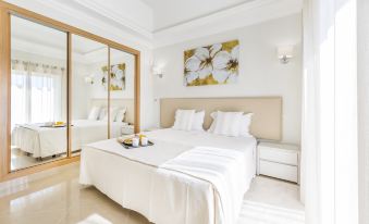 a large white bed with a tray of snacks on it is in a bedroom with two lamps at Lakeside Country Club