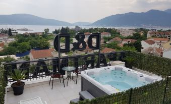 a hot tub on the roof of a building , surrounded by trees and mountains in the background at D&D Apartments