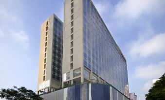 A large building with an office tower in the middle and additional buildings on both sides at V Hotel Lavender