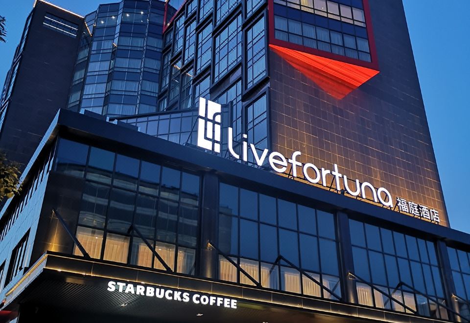 The hotel has a large glass and steel building in front, providing an impressive exterior view at night at Livefortuna Hotel