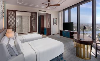 a modern hotel room with two beds , a tv , and a window overlooking the city at Melia Vinpearl Hue