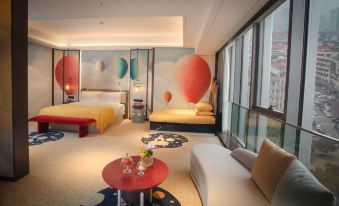 The room is decorated in an oriental style and features large windows, a bed, and a table in the center at Yindu Hotel