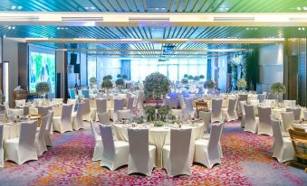 a large banquet hall filled with round tables and chairs , ready for a formal event at DoubleTree Resort by Hilton Hotel Penang