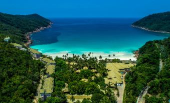 a breathtaking aerial view of a tropical beach resort with clear blue water , white sand beaches , and lush green trees at The Taaras Beach & Spa Resort