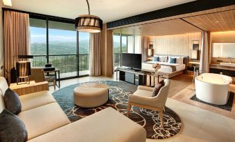 a luxurious hotel room with a king - sized bed , a flat - screen tv , a couch , and a dining table at Royal Tulip Golf Resort Gunung Geulis
