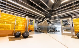 A spacious room with numerous hanging lights on the ceiling, accompanied by an indoor gym at WM HOTEL HONG KONG, Vignette Collection