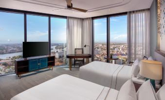 a hotel room with two beds , a television , and a view of the city outside the window at Melia Vinpearl Hue