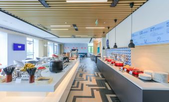 A restaurant featuring large windows, tables in the middle, and an open concept kitchen at Holiday Inn Express Shanghai Pudong Airport