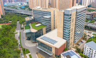 aerial view of a city with tall buildings , including a hospital and a bridge , surrounded by greenery at Kusatsu Hotel