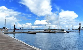 a dock on the water with several boats docked , creating a picturesque scene under a blue sky at Duyong Marina & Resort