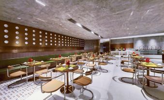 a large dining room with multiple tables and chairs arranged for a group of people to enjoy a meal together at Guangzhou Hotel