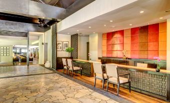 a modern hotel lobby with a stone floor , wooden reception desk , and multiple chairs arranged around it at The Taaras Beach & Spa Resort