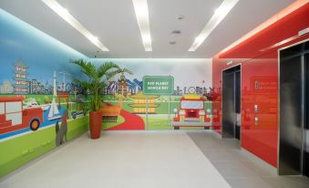 a brightly colored mural on the wall of a room , with a car parked in the background at Red Planet Manila Bay