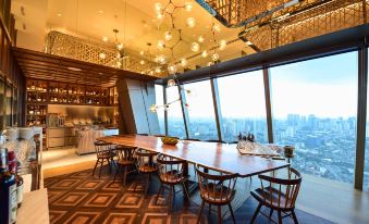 a large dining table surrounded by chairs in a room with a view of the city at Grand Hyatt Manila