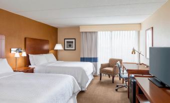 a hotel room with two beds , a chair , and a window , all neatly arranged in a hotel room at Four Points by Sheraton Chicago O'Hare