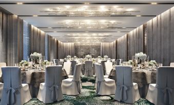 a large banquet hall filled with tables and chairs , ready for a formal event or a wedding reception at Banyan Tree Krabi