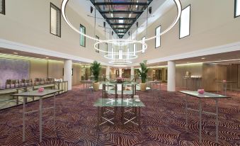 a spacious room with a carpeted floor and a chandelier hanging from the ceiling , providing illumination at Waldorf Astoria Berlin