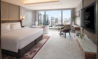 The bedroom features large windows and a balcony that offer a city view, complemented by an elegant bed at Aira Hotel Bangkok Sukhumvit 11