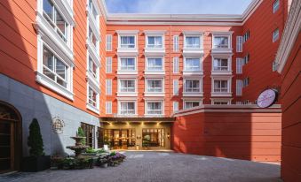 A rendering depicts the front entrance of a diverse apartment complex with various types of units at Foshan Lushan Hotel (Shunde Qinghuiyuan)