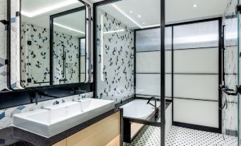 The bathroom features two sinks with a large mirror above them, as well as an open shower area at Lisboeta Macau