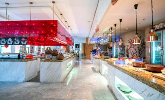 The restaurant features a wide variety of food displayed on the counter, complemented by an open concept layout at Ramada Plaza by Wyndham Shanghai Pudong Airport
