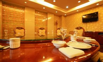 a dining room with a wooden table and chairs , along with various cups and bowls placed on the table at Frontier Building