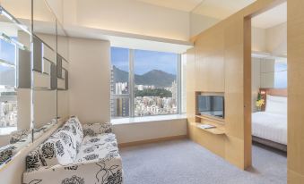 The bedroom features large windows and a balcony that offers a scenic view of the city, providing convenient access at Dorsett Mongkok Hong Kong