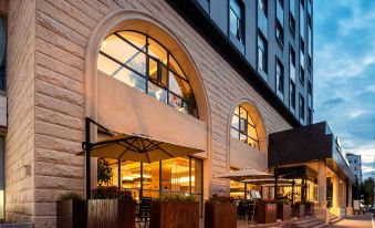 The hotel's front entrance features an outside view and a stone walkway leading up to it at UrCove by HYATT Shanghai Jing'an