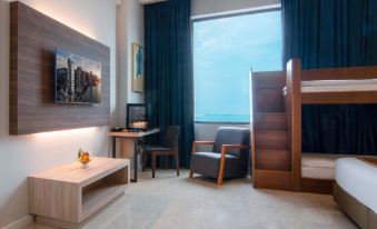 a modern hotel room with a bunk bed , desk , and tv , all situated in a minimalist style at Hompton Hotel by The Beach