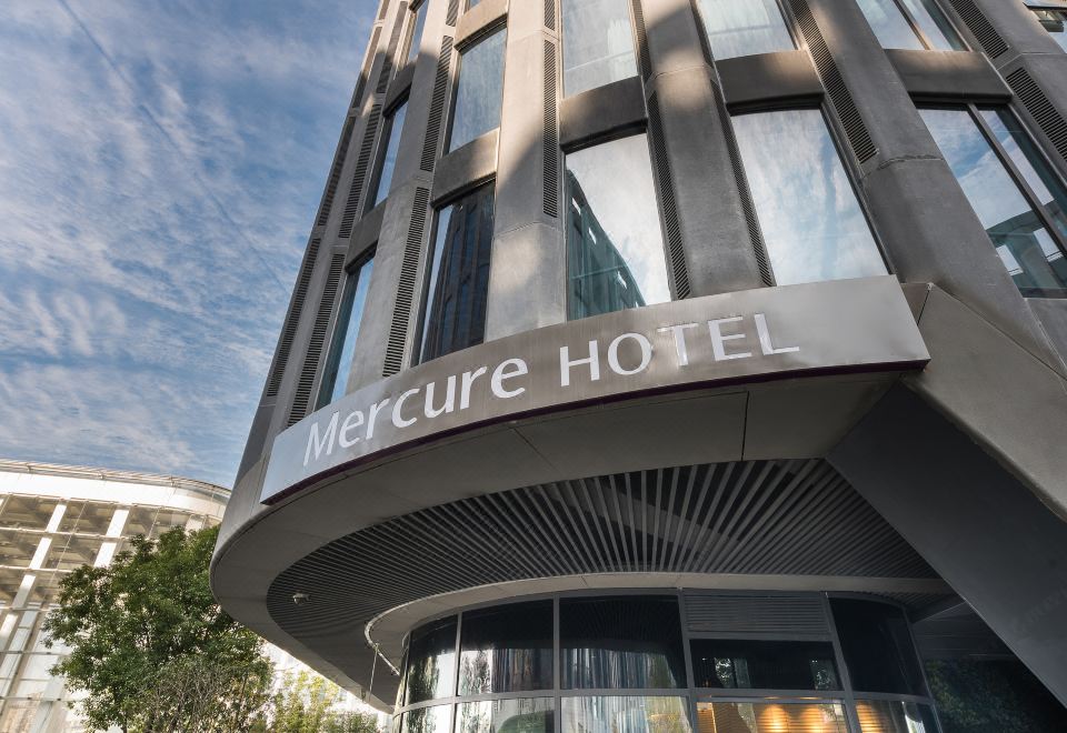 The hotel's front entrance showcases a captivating architectural feature on its facade, including glass panels at Mercure Hotel (Shanghai Hongqiao Railway Station)