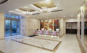 The hotel has a spacious lobby or reception area adorned with chandeliers and marble countertops at Howard Johnson Huaihai Hotel Shanghai