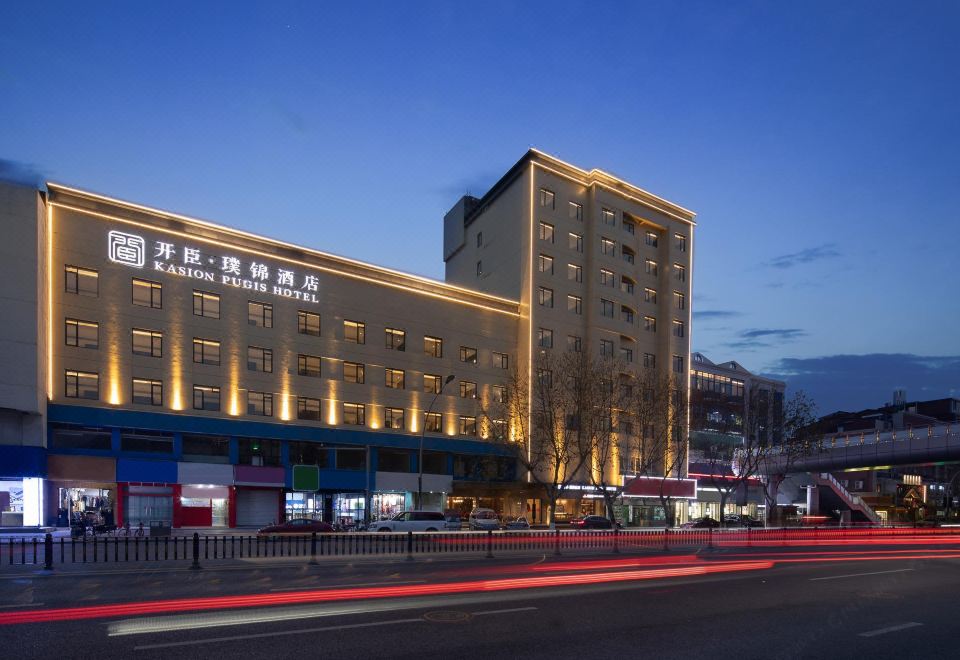 The building where a hotel is located is illuminated with neon lights at night at Kasion Pugis Hotel (Yiwu International Trade City)
