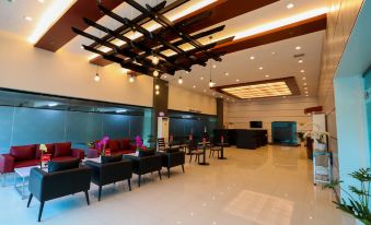 A central lobby area with tables and chairs, adjacent to a seating area at Hotel Sogo Macapagal