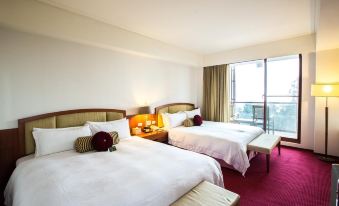 a hotel room with two beds , one on the left and one on the right side of the room at Alishan House