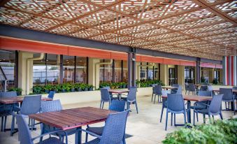 an outdoor dining area with several tables and chairs , creating a pleasant atmosphere for patrons at Highlander Hotel & Apartments