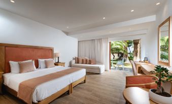 a spacious bedroom with a king - sized bed , a couch , and a large window overlooking the ocean at Civitel Creta Beach