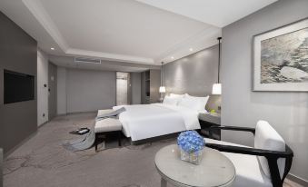 A spacious room is elegantly furnished with a bed, chair, and table in the center at Byland Star Hotel (Yiwu International Trade City)