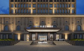 At night, a hotel's front entrance is illuminated by a sign above it, surrounded by other buildings at Kyriad Marvelous Hotel (Xinyu Jiuding Kongmujiang Store)