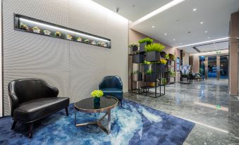 The lobby features a spacious table and chairs, as well as additional furniture on both sides at Home Inn (Shanghai Pudong Airport)