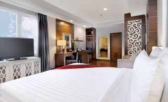 a modern hotel room with a large bed , white bedding , and black and white patterned curtains at Pranaya Boutique Hotel