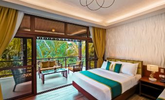 a large bed with a wooden headboard is in a room with a sliding glass door leading to an outdoor patio at Loboc River Resort