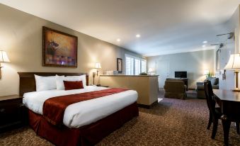 a hotel room with a large bed , a desk , and a chair , all neatly arranged at Grand Vista Hotel