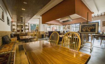 The dining room area of the restaurant is spacious and furnished with wooden tables and chairs at Hotel Blanche