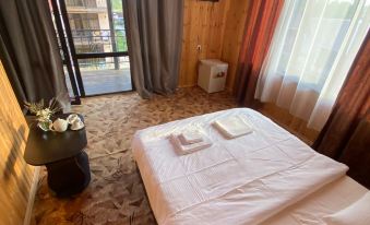 a hotel room with a bed , curtains , and a tv , as well as a balcony overlooking a mountain view at ELION